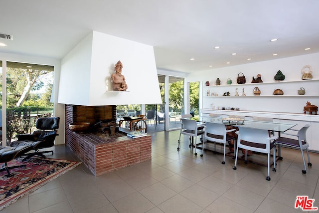 dining space featuring expansive windows, a fireplace, and light tile patterned floors