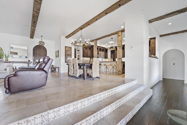 living room with beam ceiling and a chandelier