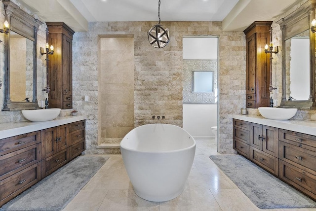 bathroom featuring a washtub, tile walls, and vanity