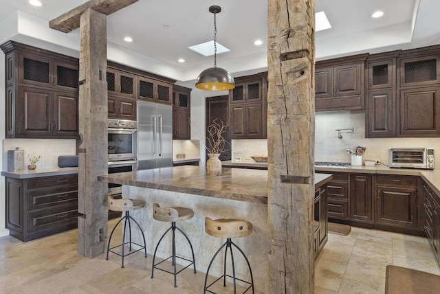 kitchen featuring dark brown cabinetry, stainless steel appliances, and a center island