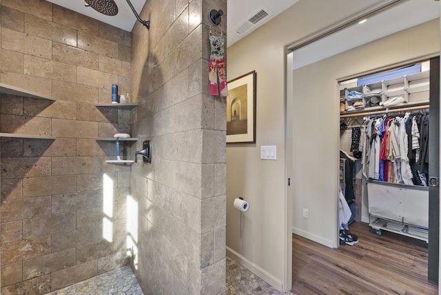 bathroom featuring wood-type flooring and tiled shower