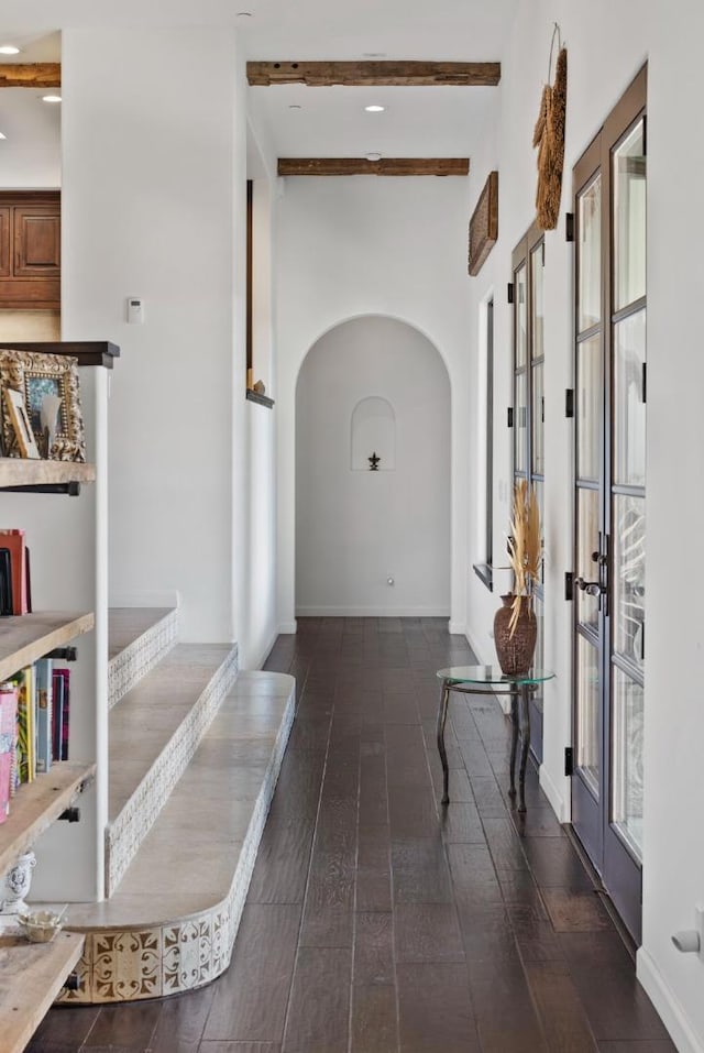 hall featuring dark wood-type flooring, beam ceiling, and french doors