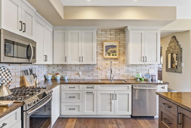 kitchen with stainless steel appliances, backsplash, white cabinetry, and sink