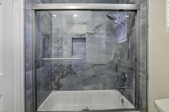 bathroom with shower / bath combination with glass door