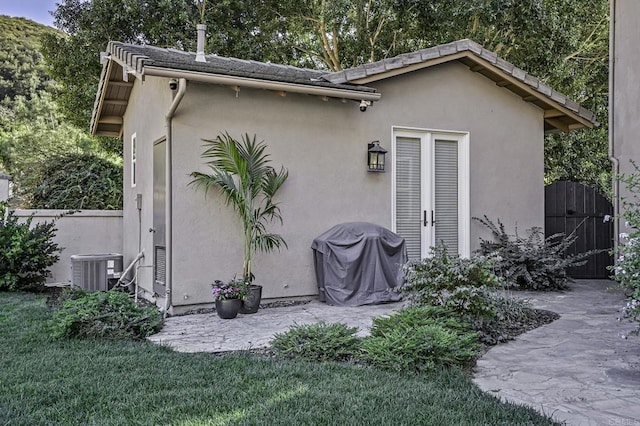 back of property with a patio, a gate, fence, stucco siding, and central air condition unit