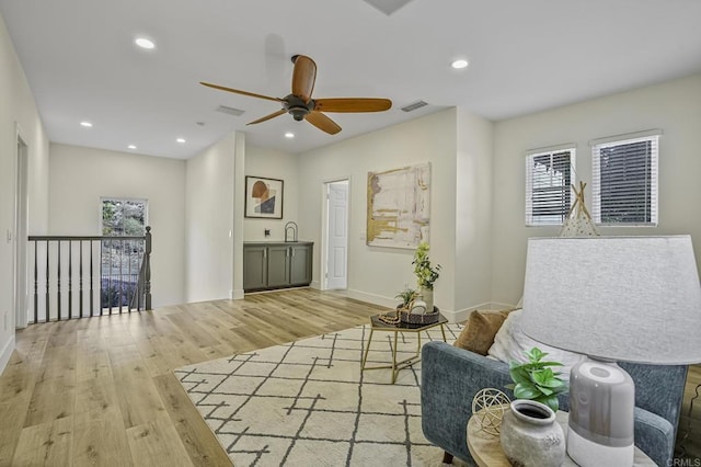 living area featuring visible vents, recessed lighting, baseboards, and wood finished floors