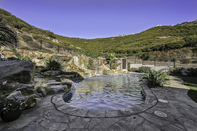 view of pool with fence and a mountain view