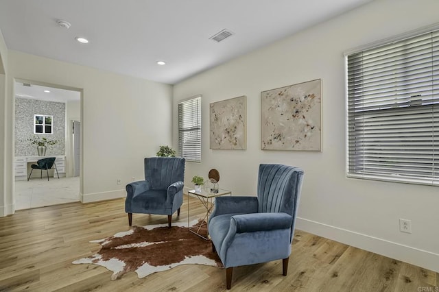 living area with recessed lighting, baseboards, visible vents, and light wood-type flooring