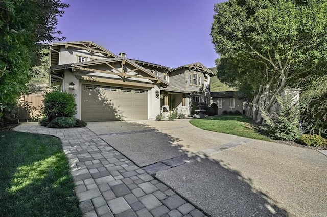 view of front of property with a front lawn, fence, driveway, and stucco siding