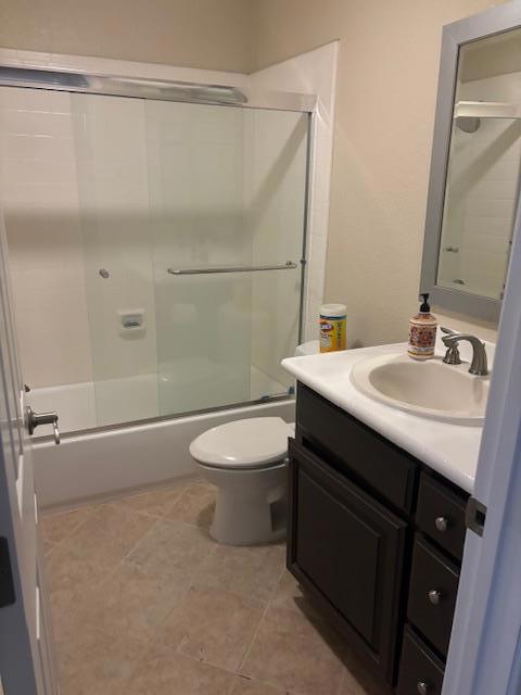 full bathroom featuring toilet, enclosed tub / shower combo, and vanity