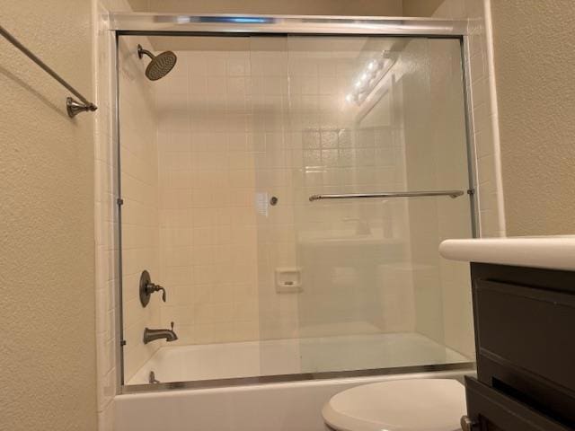 full bathroom with toilet, vanity, and shower / bath combination with glass door