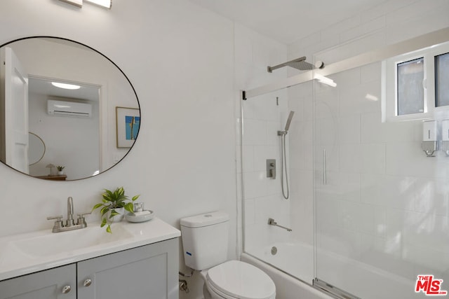 full bathroom featuring a wall mounted air conditioner, vanity, toilet, and shower / bath combination with glass door