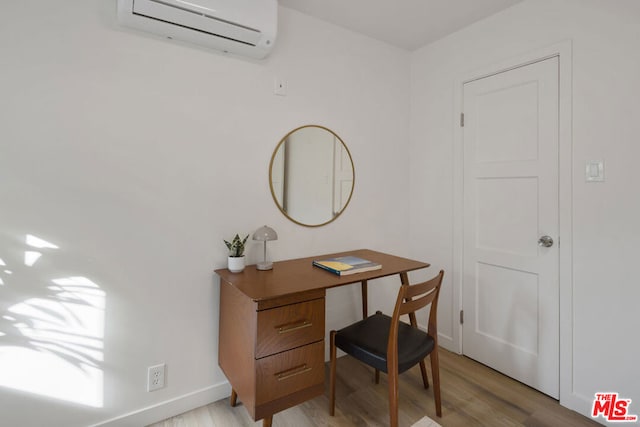 office area featuring light wood-type flooring and a wall unit AC