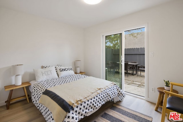 bedroom with access to outside and hardwood / wood-style flooring