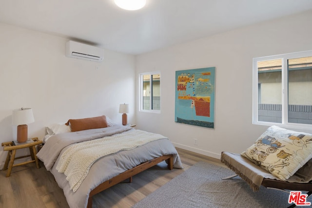 bedroom featuring a wall mounted air conditioner and dark hardwood / wood-style flooring