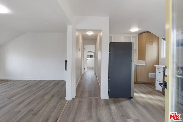 kitchen with stainless steel fridge and light hardwood / wood-style flooring