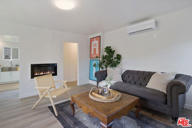 living room with a wall mounted air conditioner and hardwood / wood-style flooring