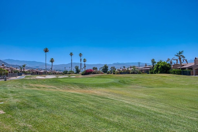 view of property's community with a mountain view and a yard