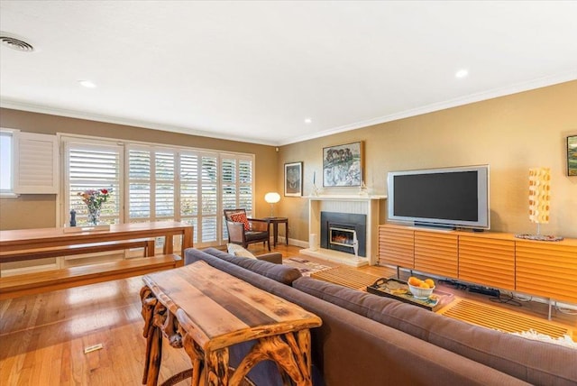 living room with light hardwood / wood-style flooring and crown molding