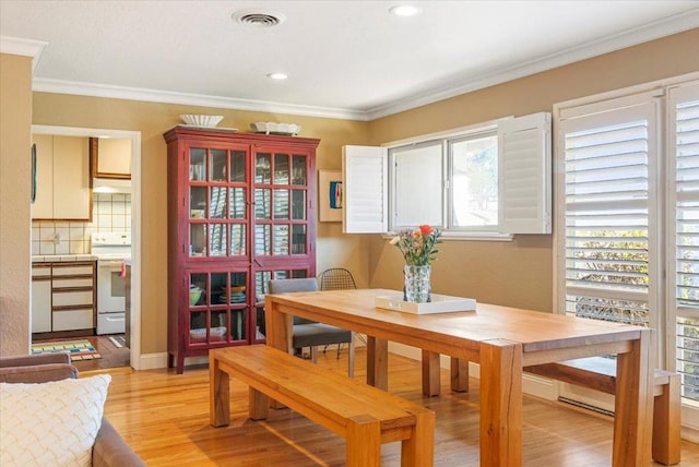 dining room featuring light wood-type flooring and ornamental molding