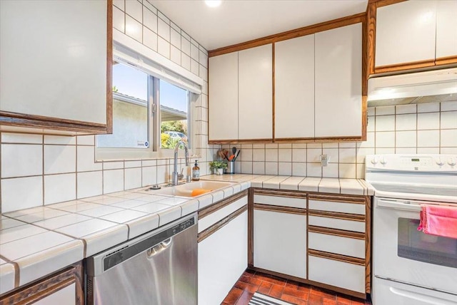 kitchen with dark tile patterned floors, dishwasher, white cabinetry, sink, and white range