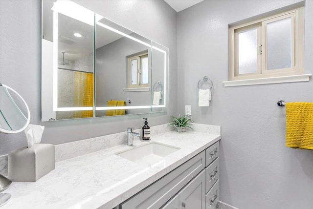 bathroom featuring vanity, a wealth of natural light, and walk in shower