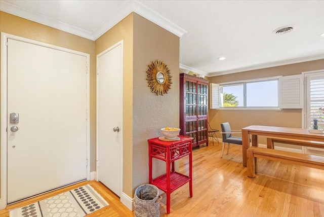 foyer featuring light hardwood / wood-style flooring and crown molding