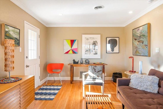 sitting room featuring crown molding and light wood-type flooring