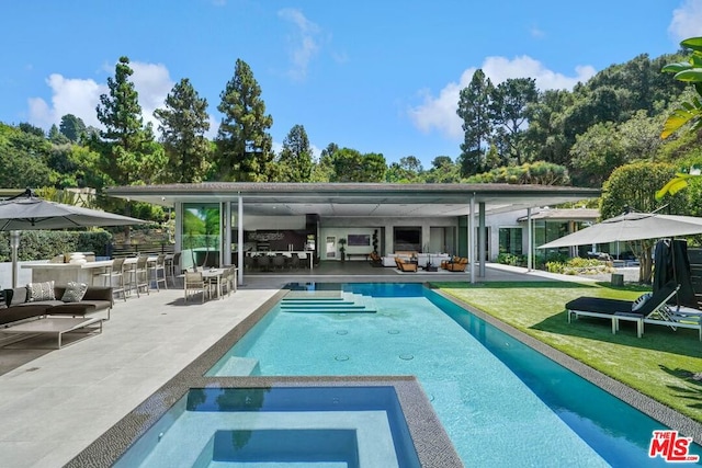 view of swimming pool featuring an outdoor bar, a yard, a patio, an outdoor hangout area, and an in ground hot tub