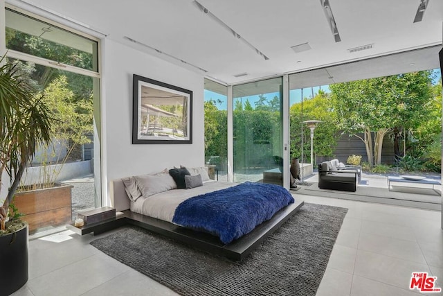 bedroom with access to outside, a wall of windows, and light tile patterned floors