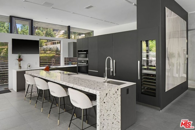 kitchen with a breakfast bar, a center island, sink, and black appliances