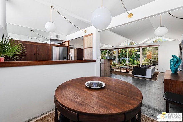 dining area with high vaulted ceiling and sink