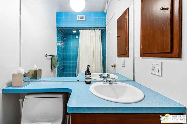 bathroom with toilet, vanity, and a shower with curtain