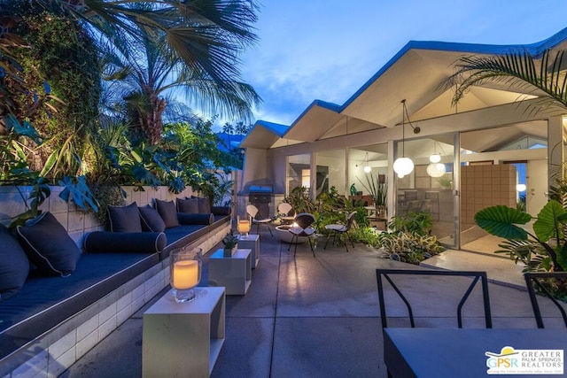 patio terrace at dusk with an outdoor living space and a grill