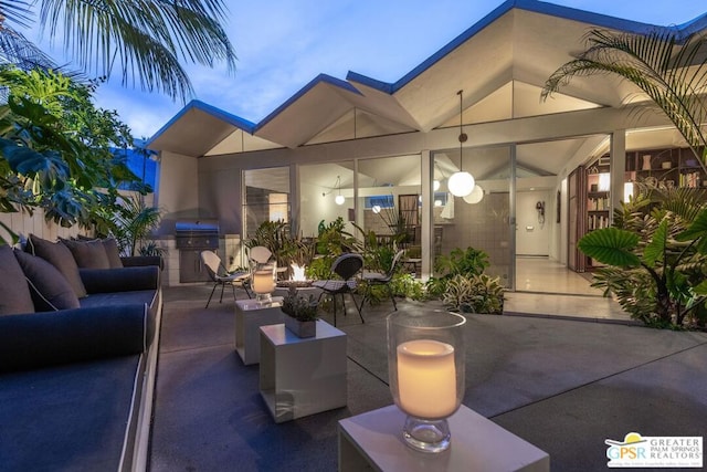 patio terrace at dusk with area for grilling and an outdoor hangout area