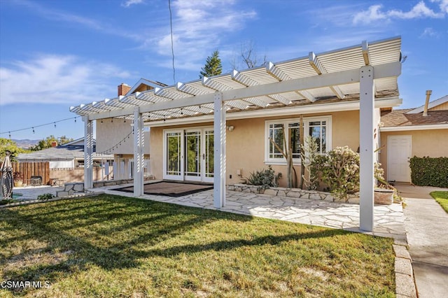 back of house featuring a lawn, a pergola, and a patio