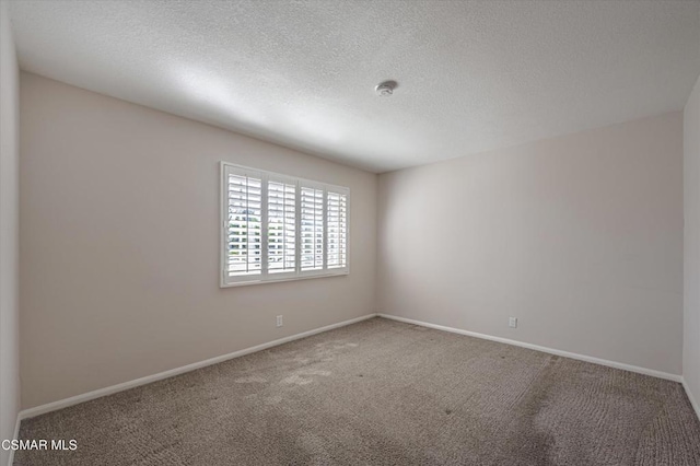 carpeted empty room with a textured ceiling