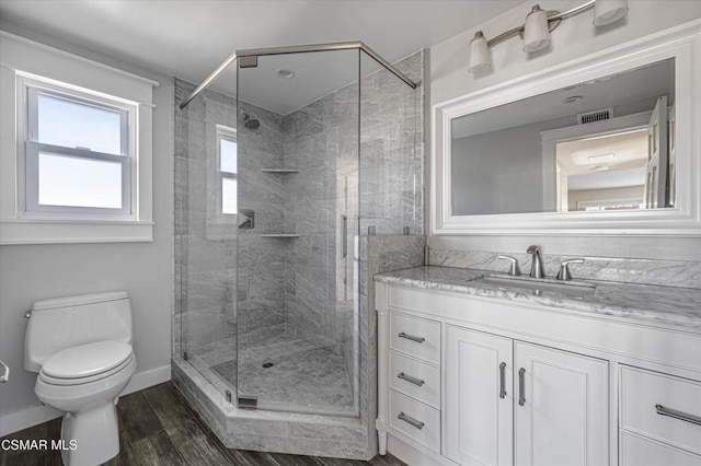 bathroom featuring toilet, walk in shower, and vanity