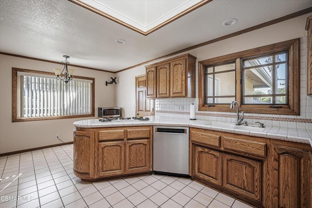 kitchen with pendant lighting, a chandelier, stainless steel appliances, backsplash, and sink