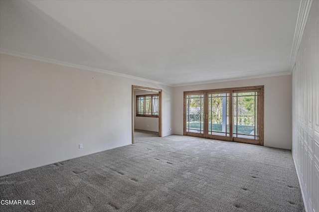 empty room with crown molding and carpet flooring