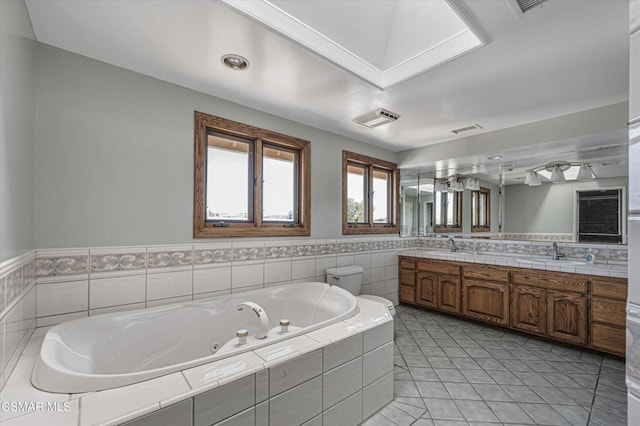 bathroom with vanity, tiled tub, and tile patterned floors