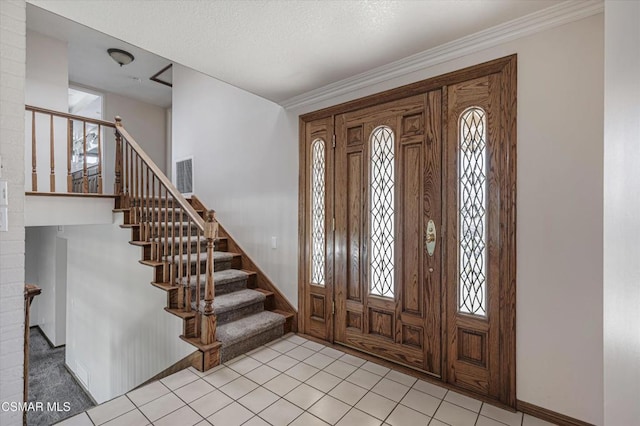 entrance foyer featuring ornamental molding, a healthy amount of sunlight, and light tile patterned floors