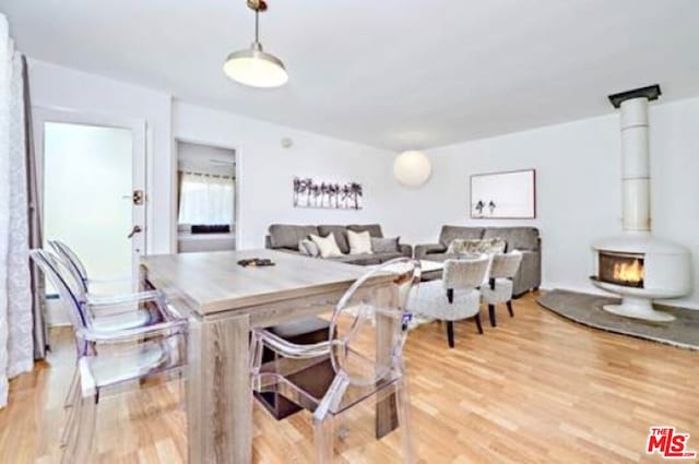 dining area featuring a wood stove and light hardwood / wood-style flooring