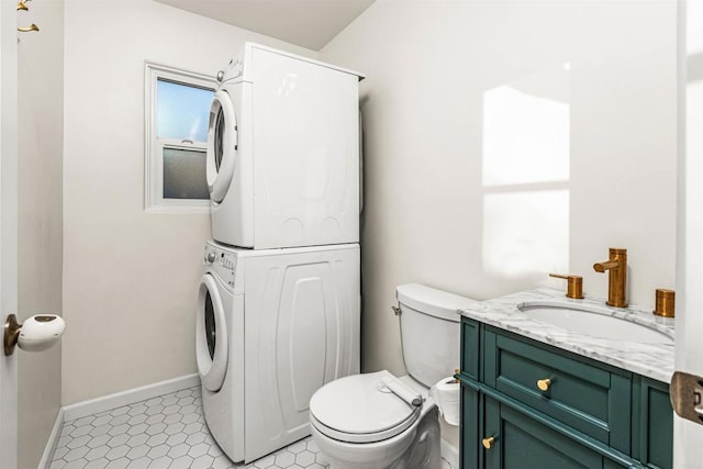 bathroom with toilet, vanity, tile patterned flooring, and stacked washer / dryer