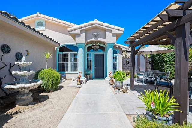 entrance to property featuring a pergola and a patio area