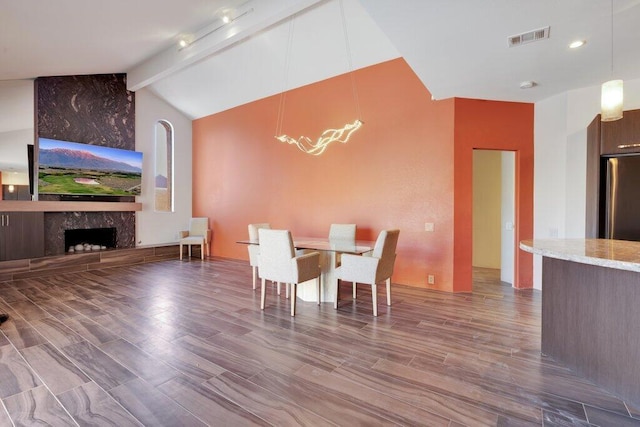 unfurnished dining area featuring a fireplace and lofted ceiling with beams