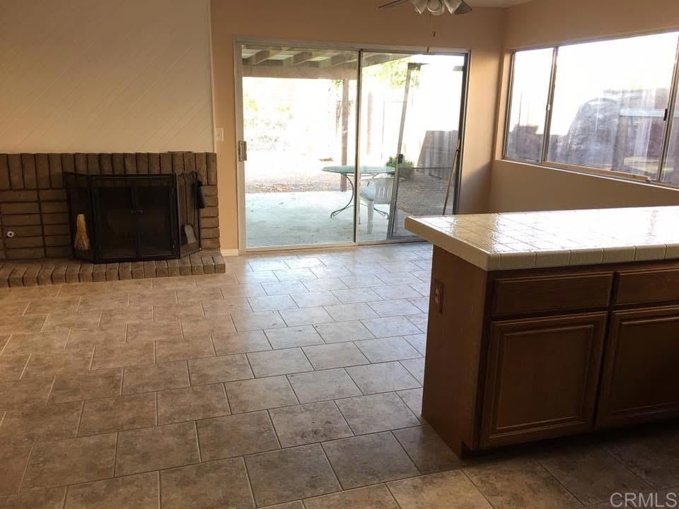 interior space with ceiling fan and a brick fireplace