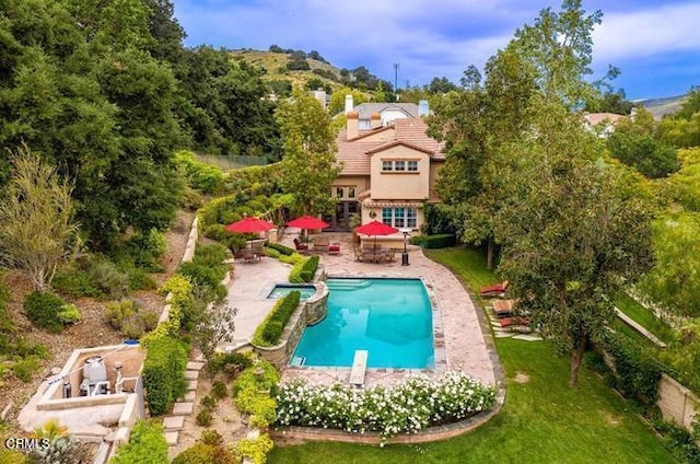 view of swimming pool featuring a patio area, a diving board, and a lawn