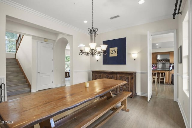 dining room with crown molding, a healthy amount of sunlight, and dark hardwood / wood-style floors