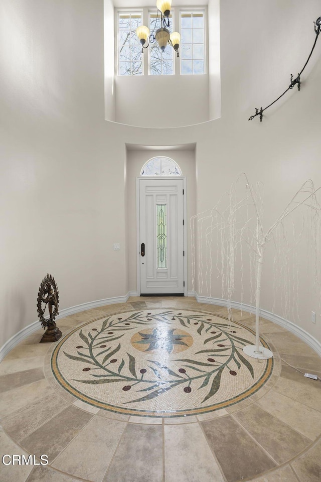 entryway with a high ceiling, a healthy amount of sunlight, and a notable chandelier